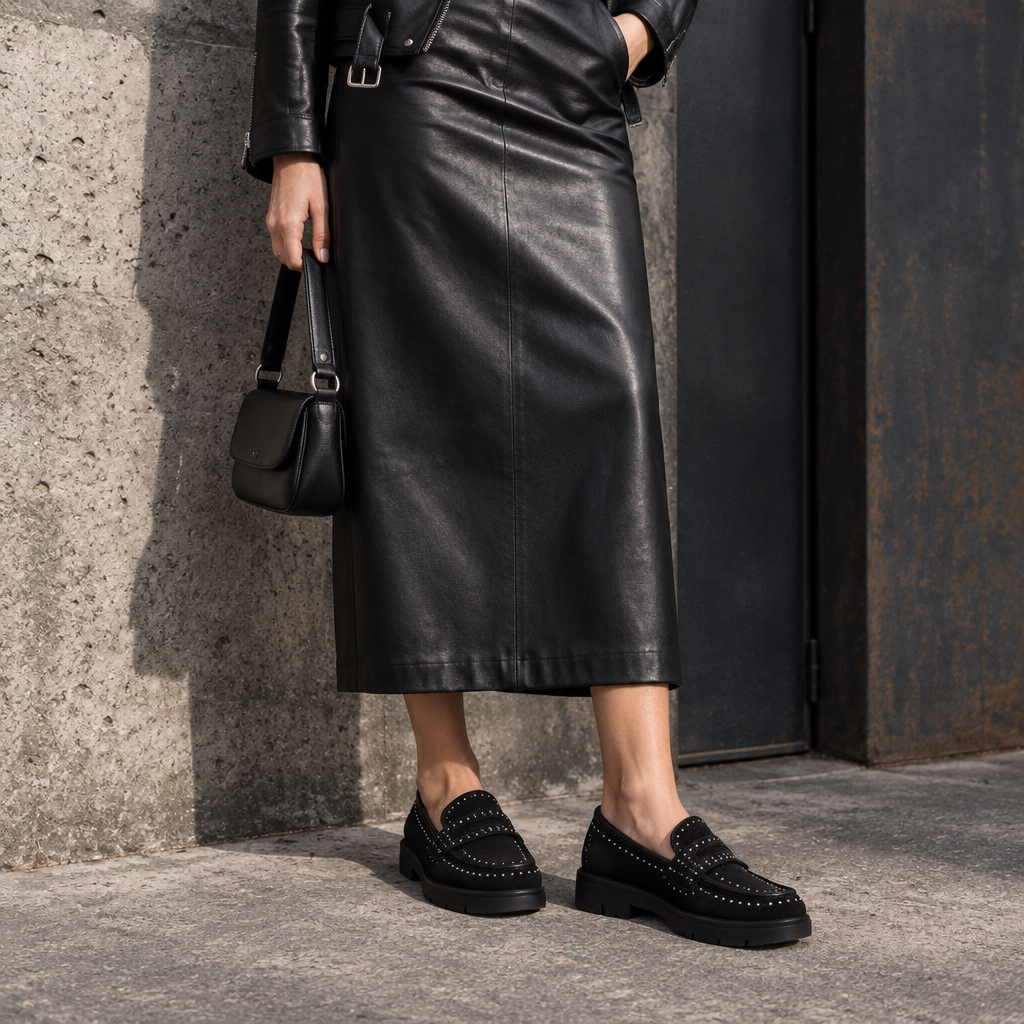 Look grintoso con gonna in pelle sotto il polpaccio e mocassini neri senza calzini