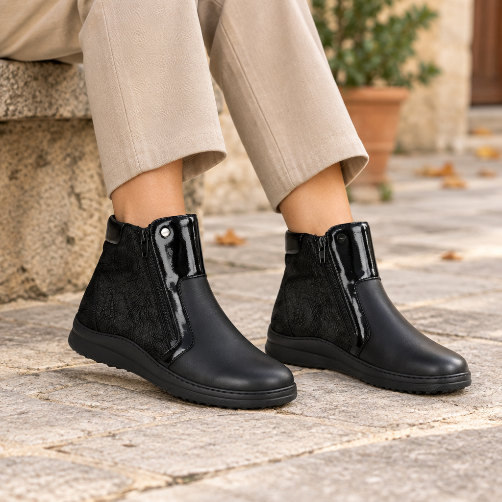 Stivaletti neri Hergos indossati con pantaloni beige